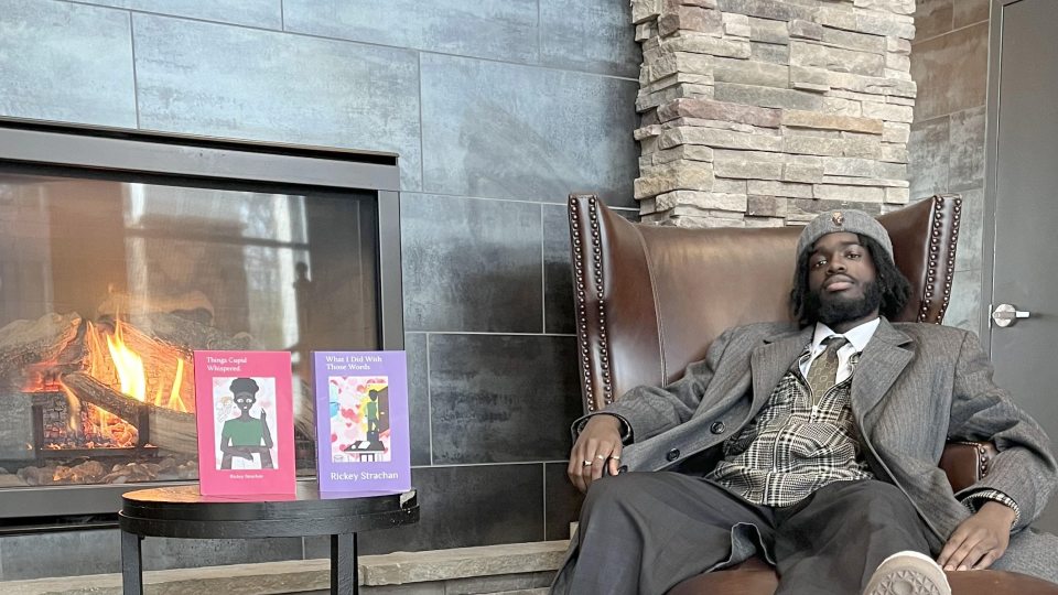 Rickey Strachan showing his books of poetry