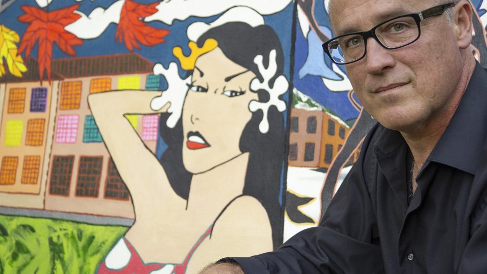 Ron Throop with a painting on Roy Lichtenstein's time in Oswego