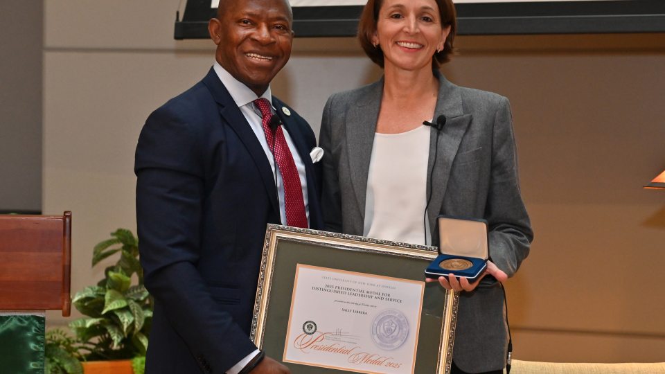 SUNY Oswego President Peter O. Nwosu presents Sally Librera, president of National Grid NY, with the Presidential Medal on Oct. 24, 2025, during the second annual Sheldon Lecture on Leadership and Service