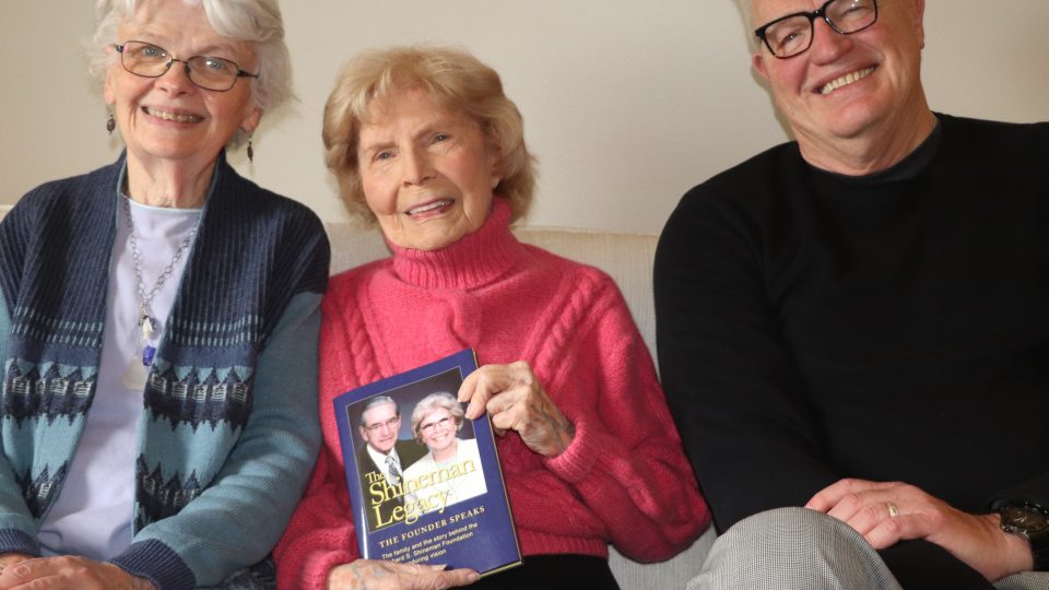 Kathy Fenlon and Jeff Rea present Barbara Shineman with a copy of The Shineman Legacy book