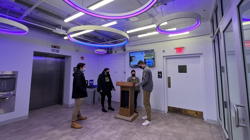 Admissions interns check in visitors for a program in The Space