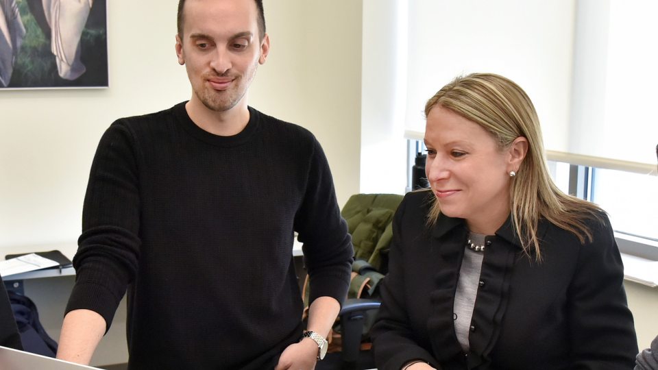 Michelle Storie and Marcus Lombardo review projects on a computer