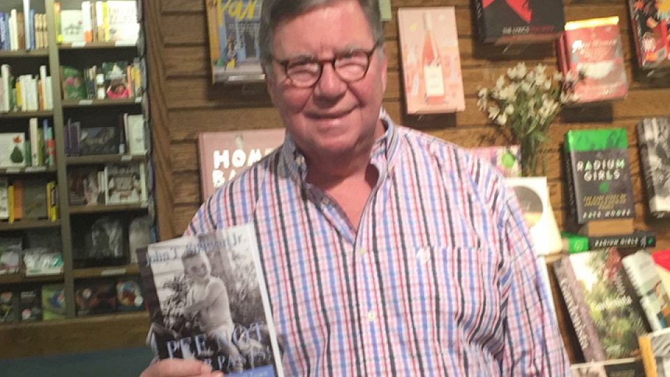 John Sullivan holding a book with many of his stories