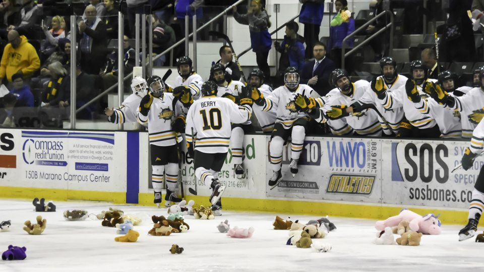 Laker hockey players celebrate goals on fans toss stuffed bears on the ice in support of Toys for Tots