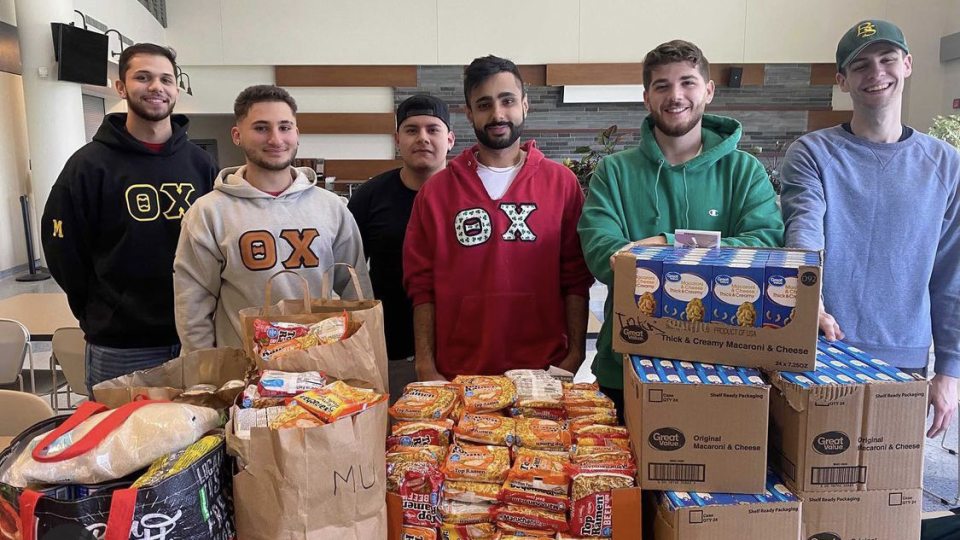Theta Chi brothers pose with their large amount of donations to the Students Helping Oz Peers pantry