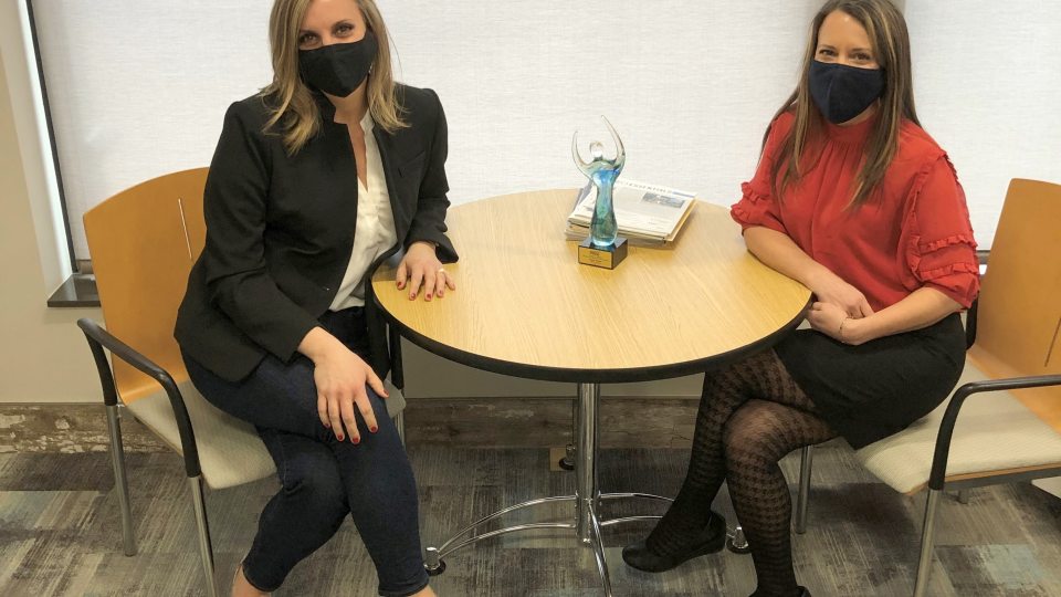 Chena Tucker (right), director of the college's Office of Business and Community Resources, receives congratulations from Katie Toomey of the Greater Oswego-Fulton Chamber of Commerce