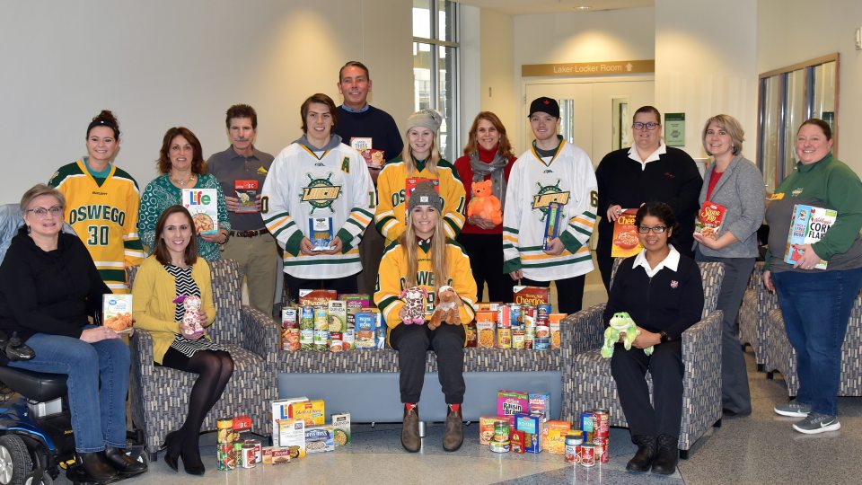Laker hockey players with United Way and campus organizers collecting toy and food donations