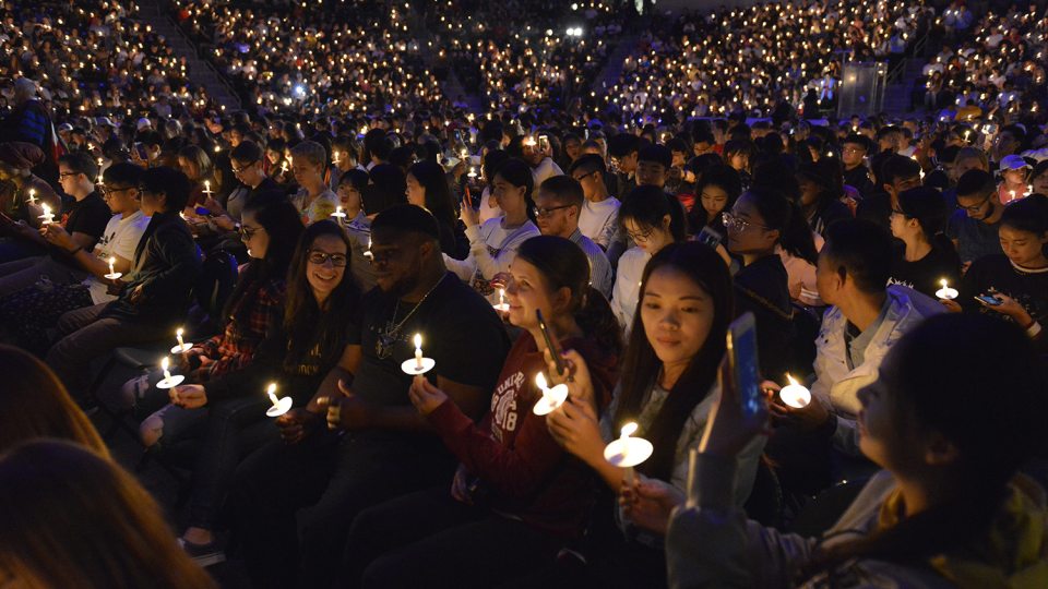 Students hold up candles at Torchlight