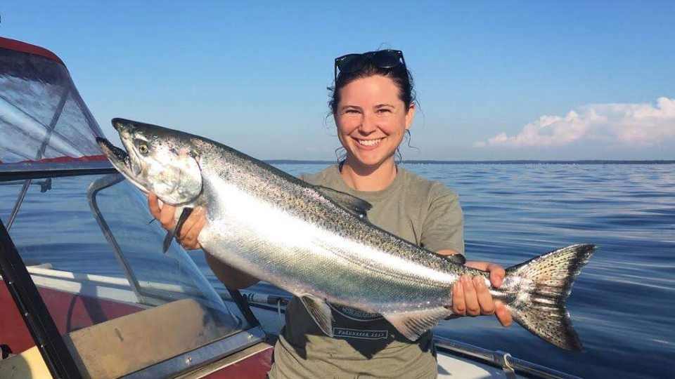 SUNY Oswego biological sciences faculty member Ellen Karboski holds an adult chinook caught on Lake Ontario.