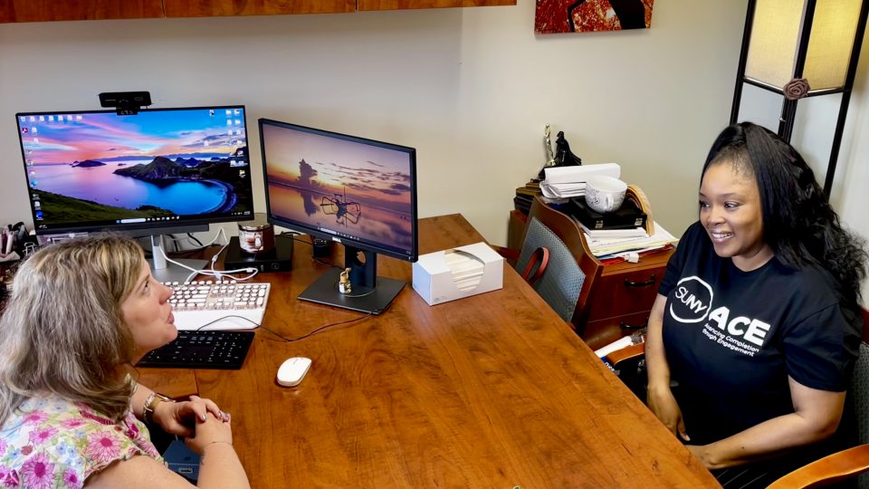 SUNY Oswego communications major and Advancing Completion through Engagement (ACE) student Melinda McCarthy (left) speaks with advisor Megan Runge in the Advisement Center.