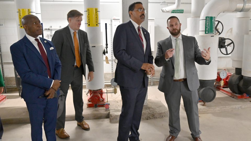 SUNY Chancellor John B. King Jr. recently toured geothermal facilities underneath Hewitt Hall. Here Director of Capital Projects Devin Reese provides details as (from left) SUNY Oswego President Peter O. Nwosu and SUNY Chief Sustainability Officer Carter Strickland look on.