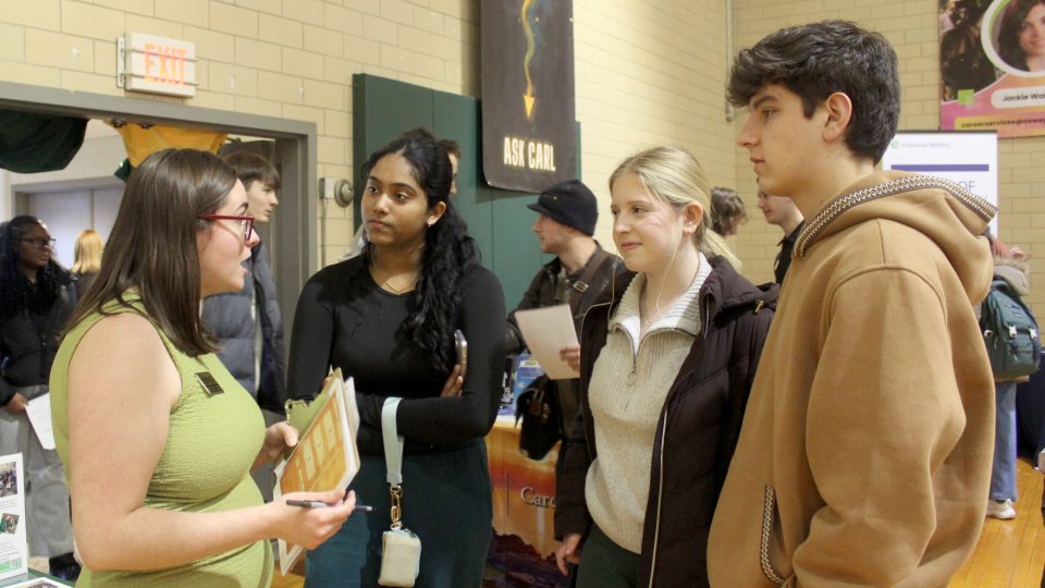 Internship coordinator and SUNY Oswego graduate Maureen (Mo) Buchanan (left) speaks with students at the spring Career Fair