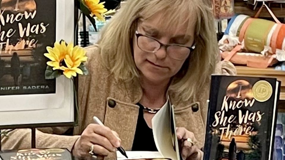 Jennifer McGill Sadera, a 1985 SUNY Oswego graduate, signs copy of her first book, "I Know She Was There"