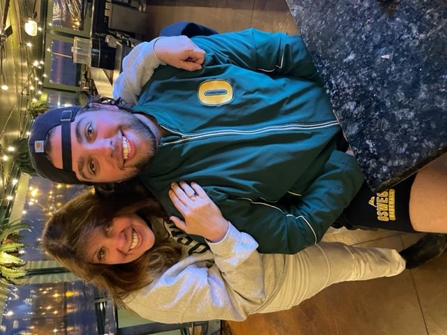 Annie and Ryan at restaurant in SUNY Oswego gear