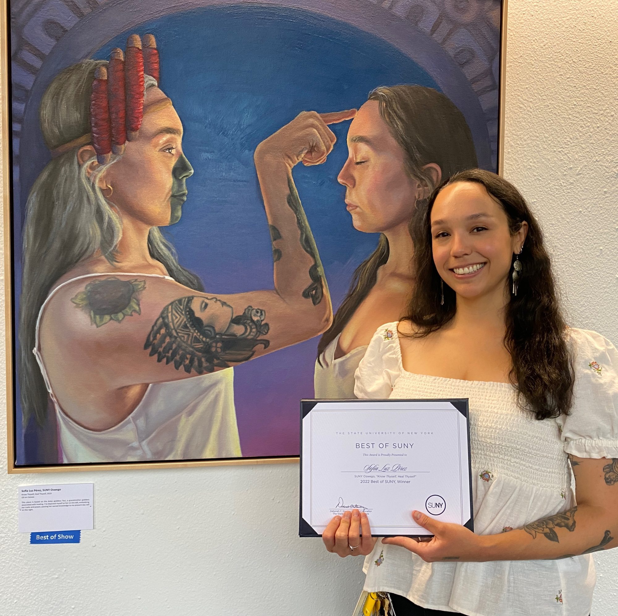 Sofia Luz Pérez stands next to her award winning painting