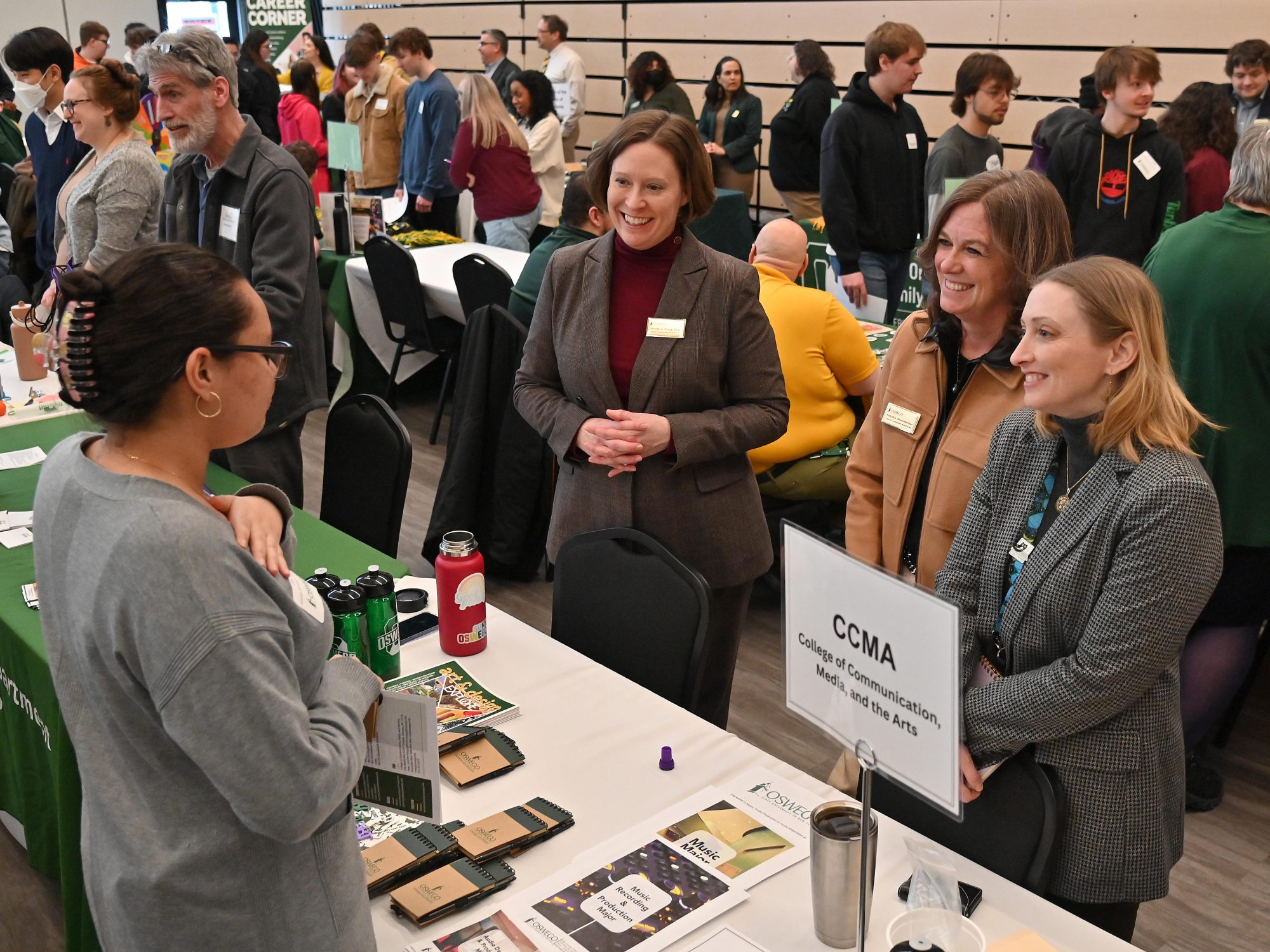 Lily Prado, a senior at George W. Fowler High School in Syracuse, speaks with College of Communication, Media and the Arts representatives (from left) Jennifer Knapp, dean; Kelly Roe, associate dean; and Davana Robedee, Tyler Art Gallery director.