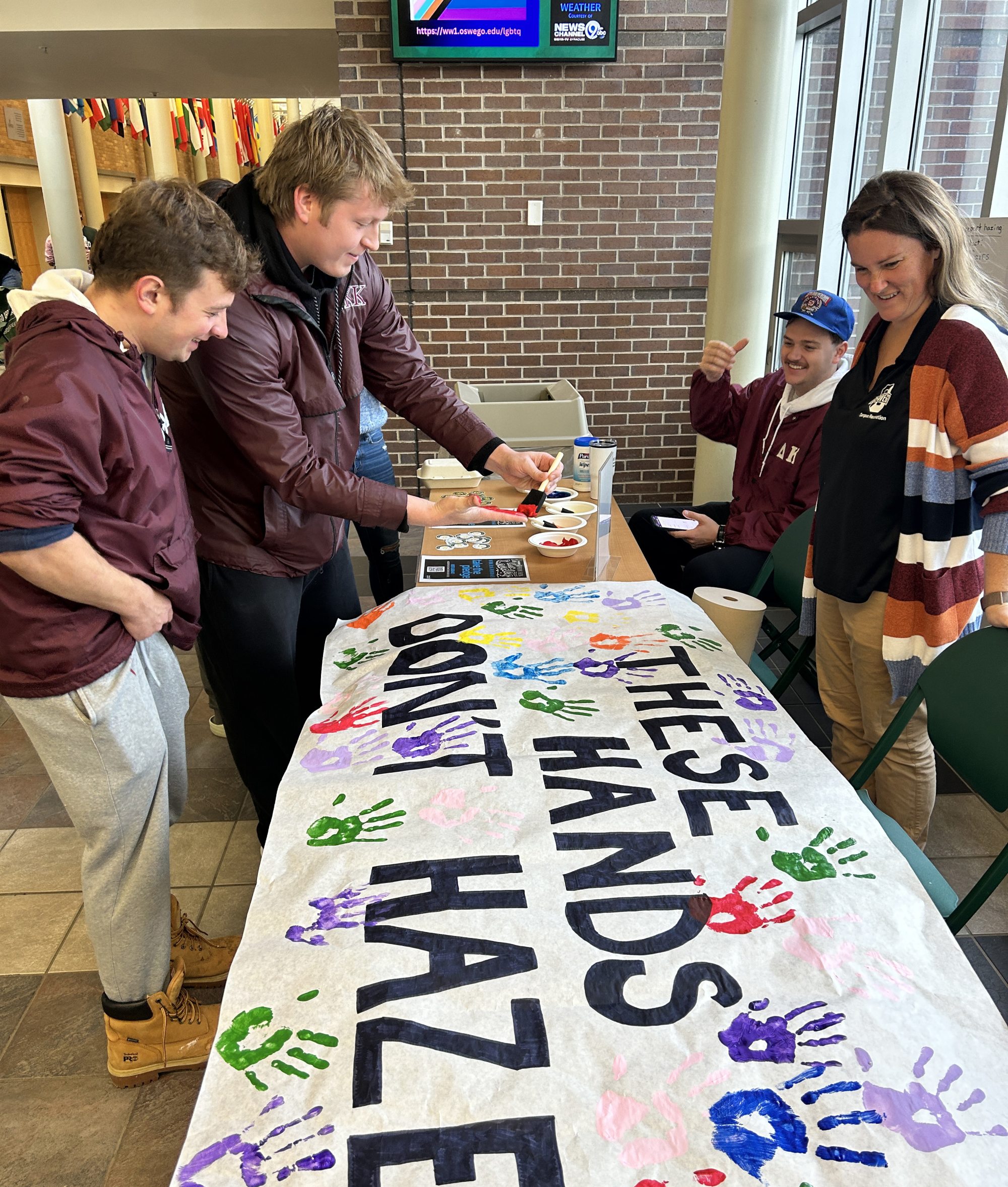 Students sign These Hands Don't Haze banner