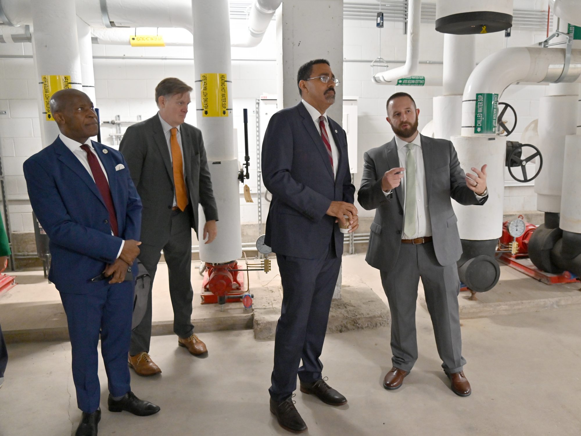 SUNY Chancellor John B. King Jr. recently toured geothermal facilities underneath Hewitt Hall. Here Director of Capital Projects Devin Reese provides details as (from left) SUNY Oswego President Peter O. Nwosu and SUNY Chief Sustainability Officer Carter Strickland look on.