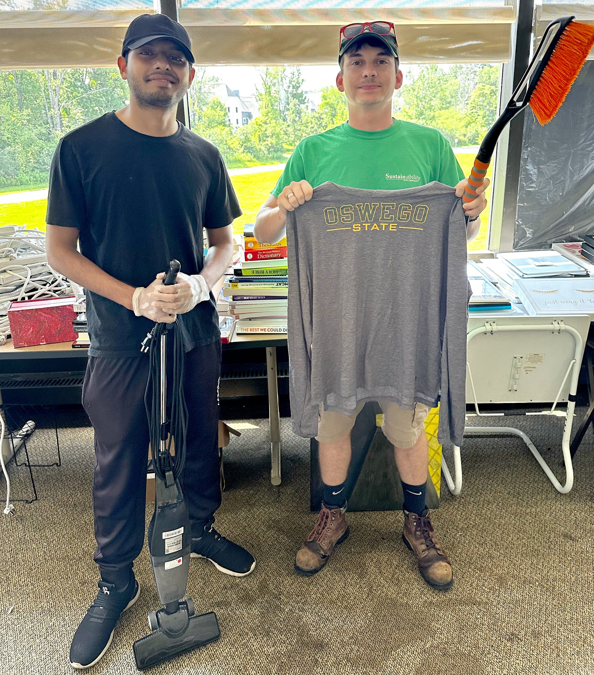 From left, Ananta Bhowmick Antik, a member of SUNY Oswego’s student sustainability team, and Maxon Ali, the university’s sustainability coordinator, show off some of the recycled items from the OzThrift effort. 