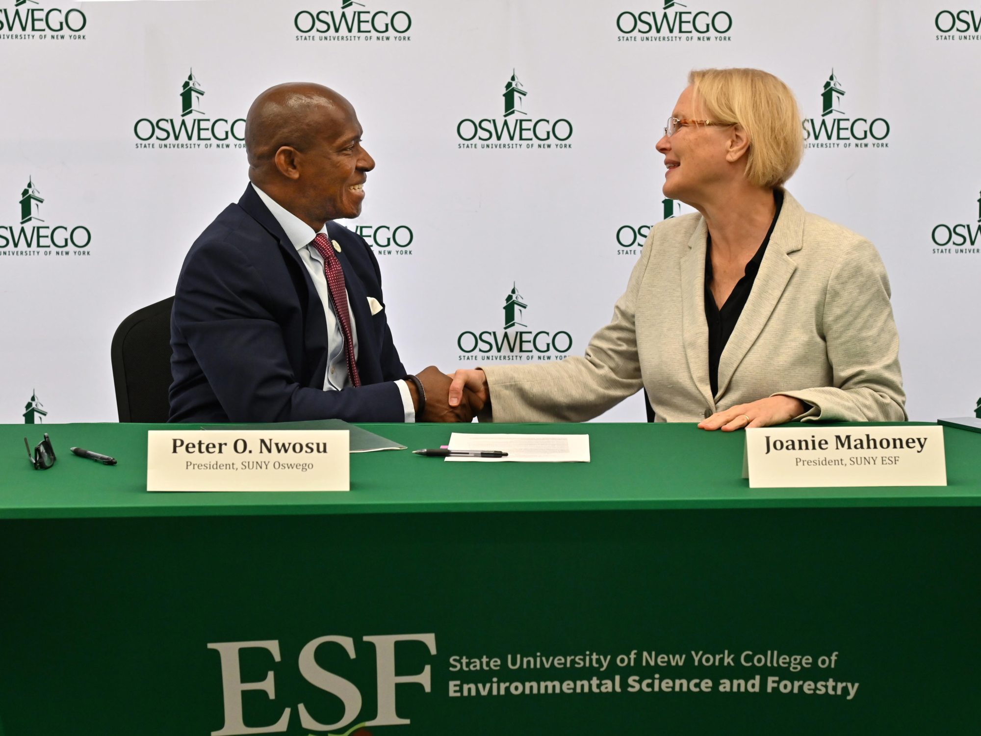 SUNY Oswego President Peter O. Nwosu shakes hands with SUNY ESF President Joanie Mahoney to finalize a shared services agreement between the institutions on Sept. 29. 