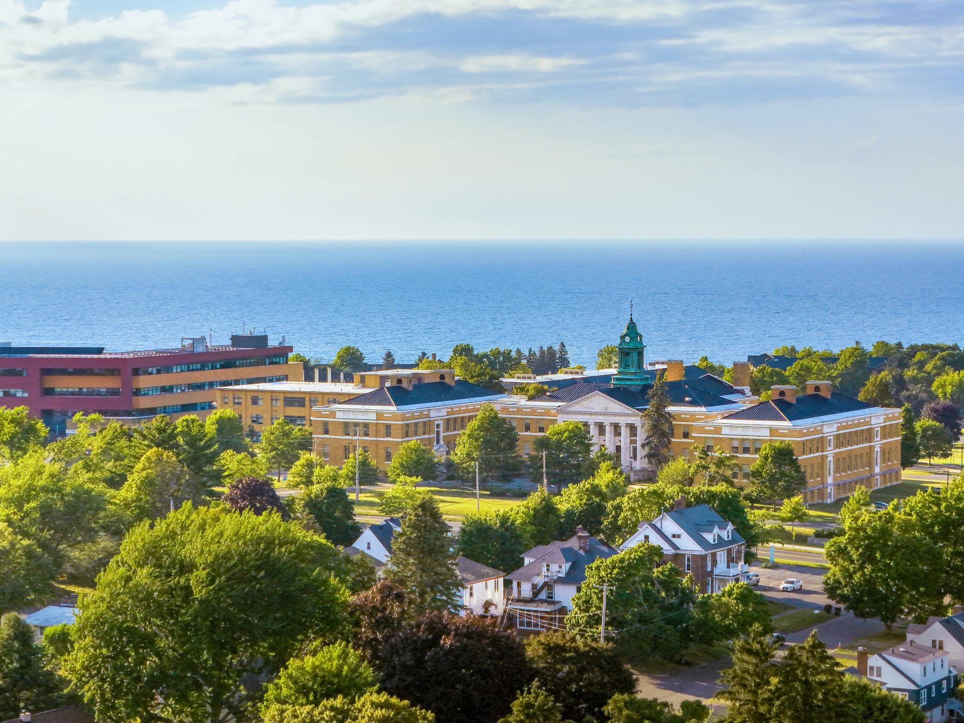 Aerial photo showing Sheldon Hall and the Shineman Center, among other buildings, with Lake Ontario in the background