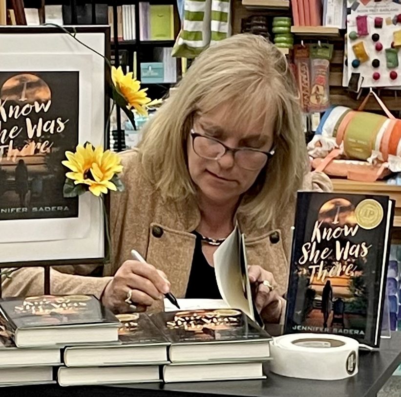 Jennifer McGill Sadera, a 1985 SUNY Oswego graduate, signs copy of her first book, "I Know She Was There"