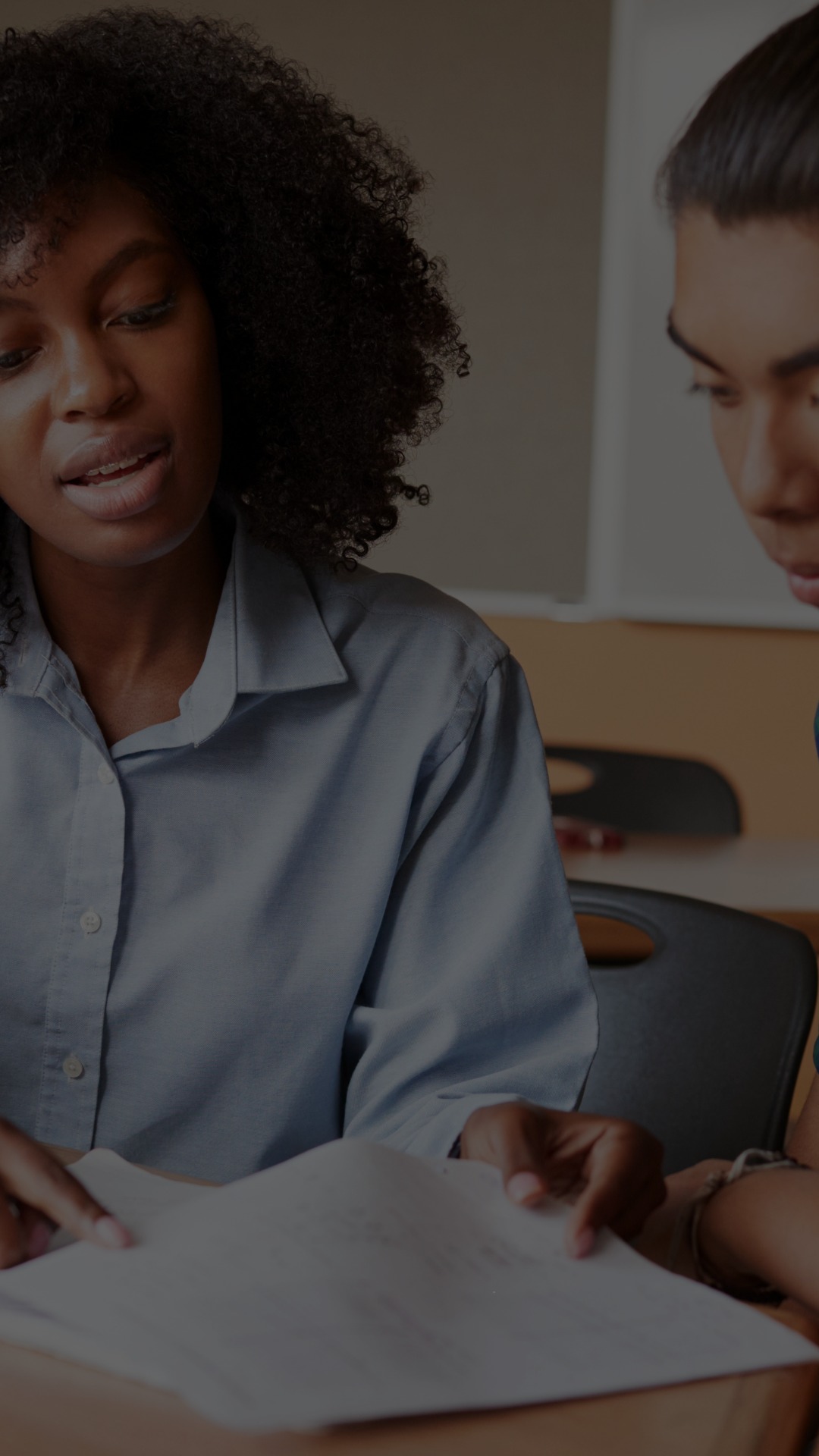 A tutor and tutee work together to edit a paper.