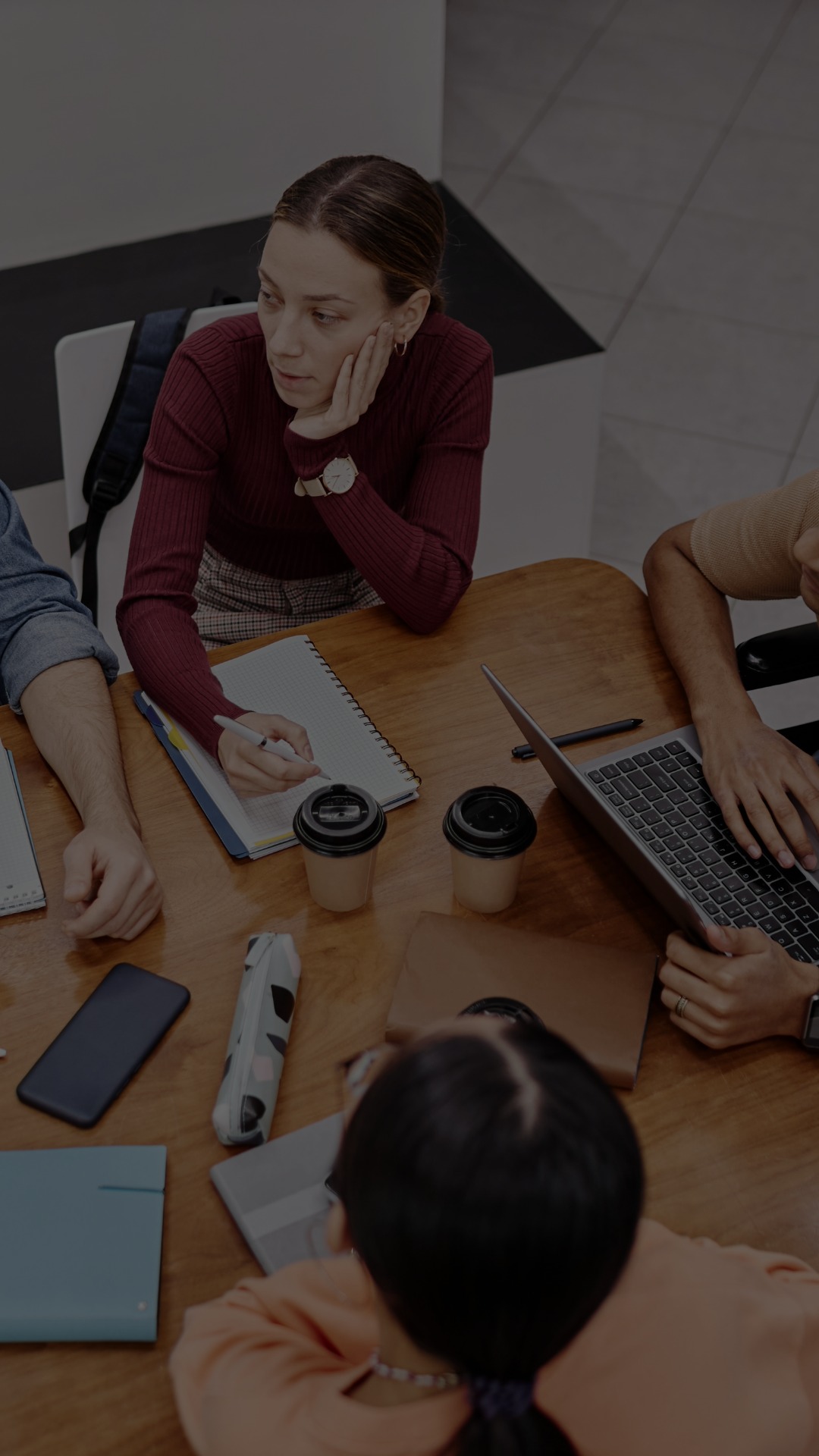 A group of college students study together at a table. 