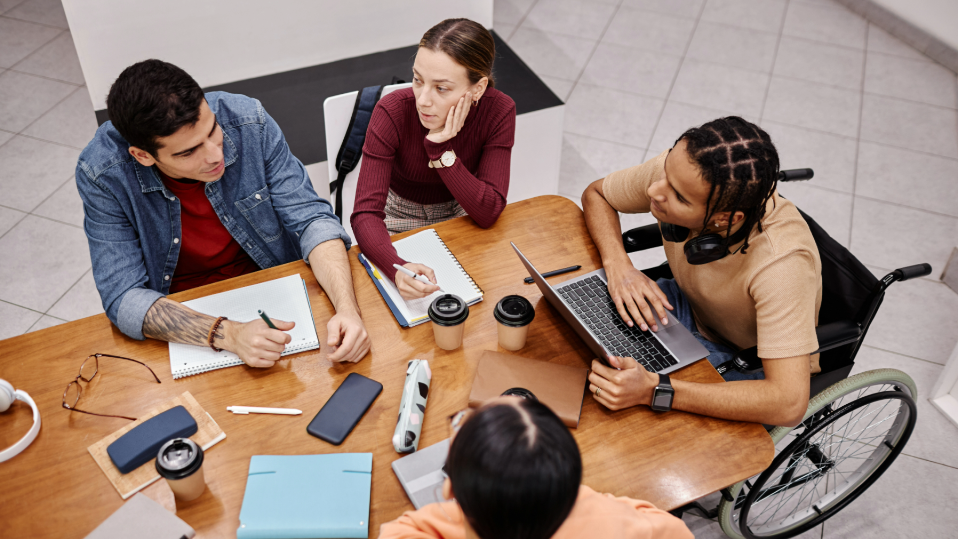 A group of four students work together at a table