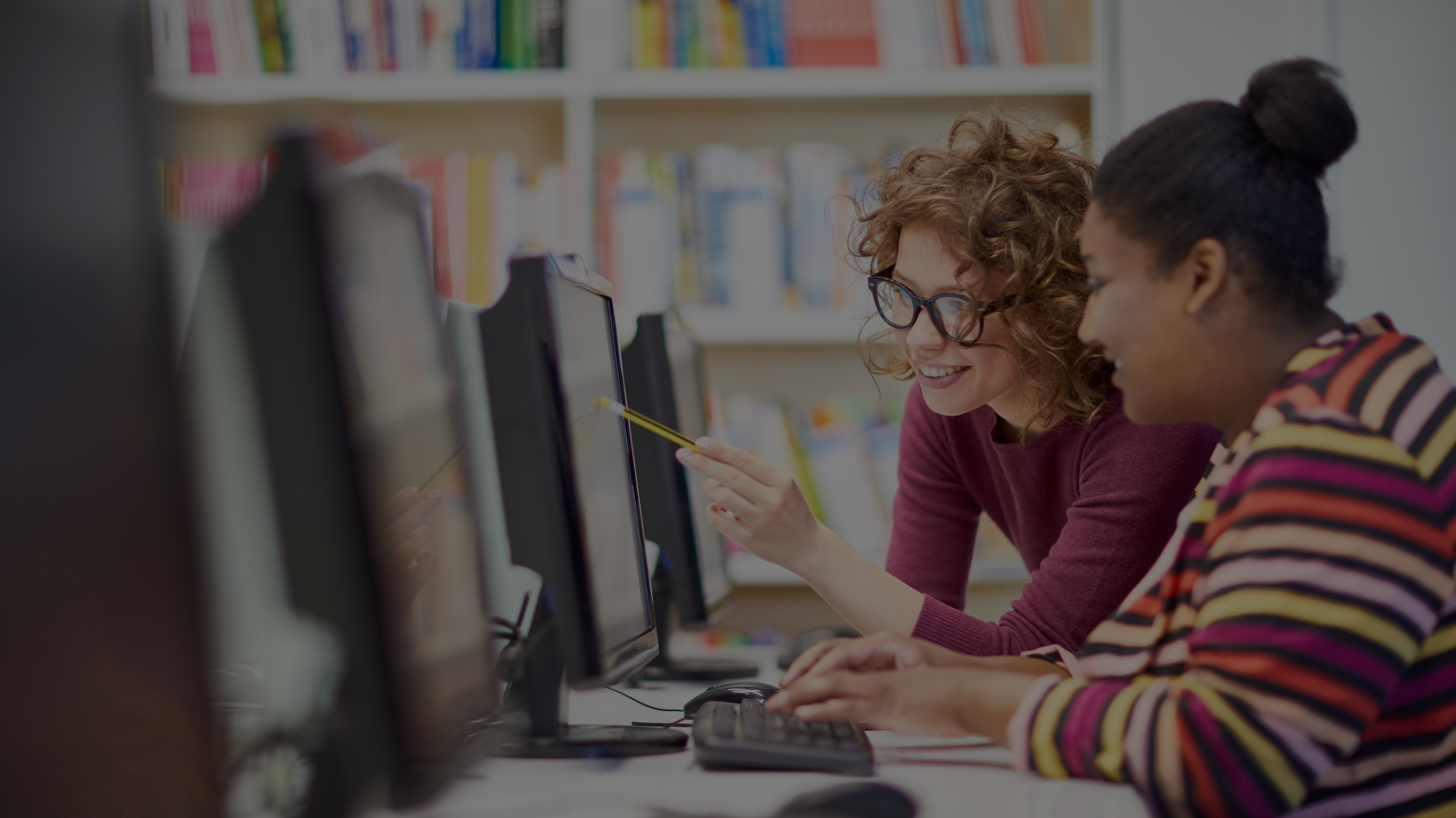 Two students work together at a computer.