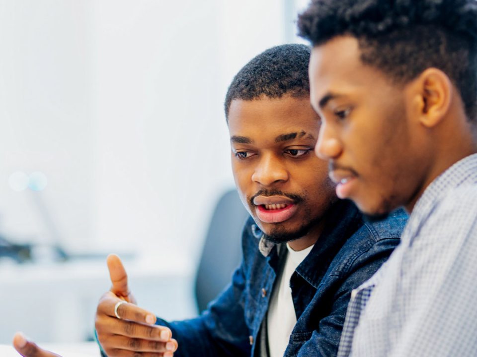 Two young men of color working on a problem together. 