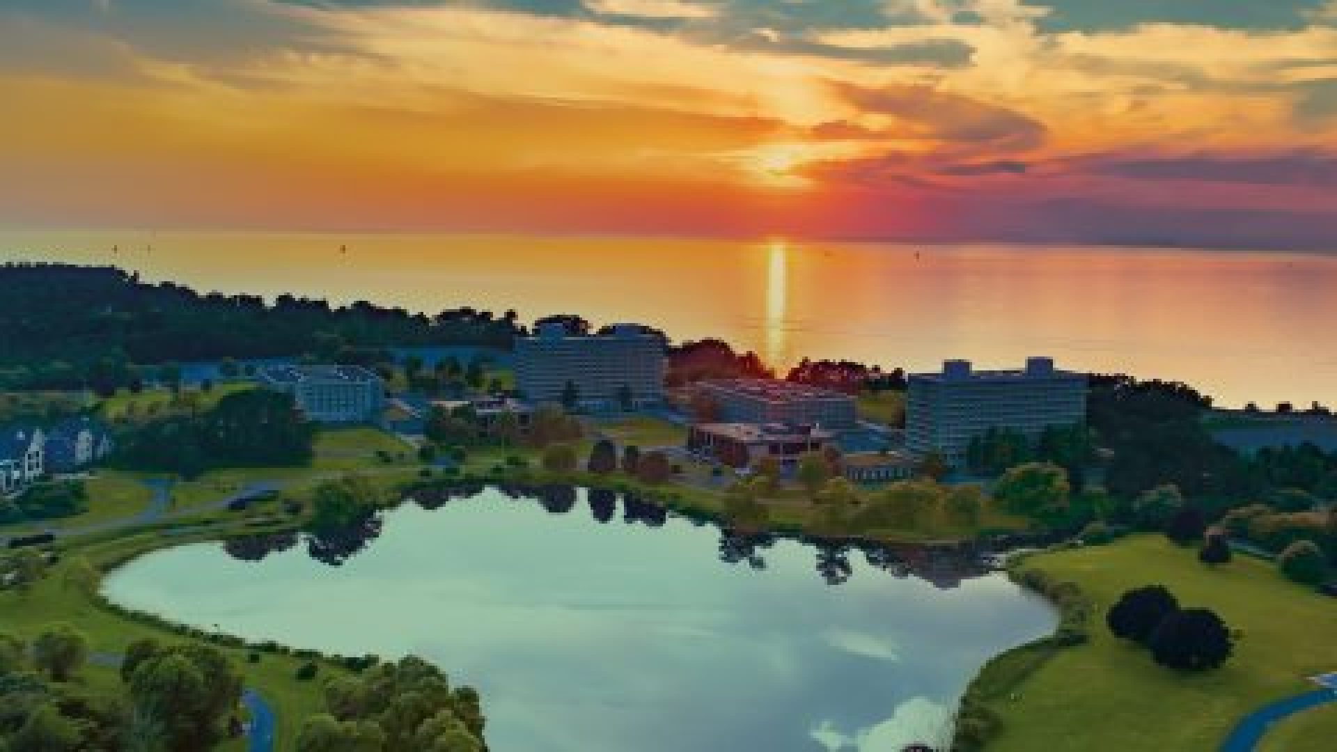 aerial view of the lagoon and Village, with a sunset over the lake