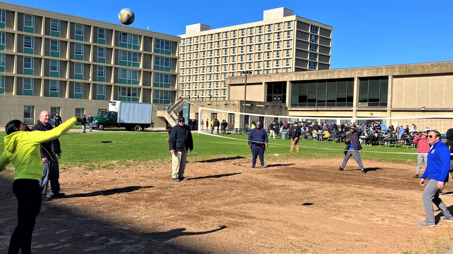 University Police officers and students participating in a volleyball game