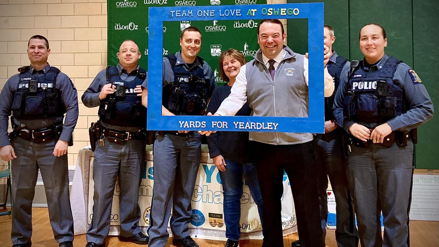University Police officers pose with a Yards for Yeardley sign