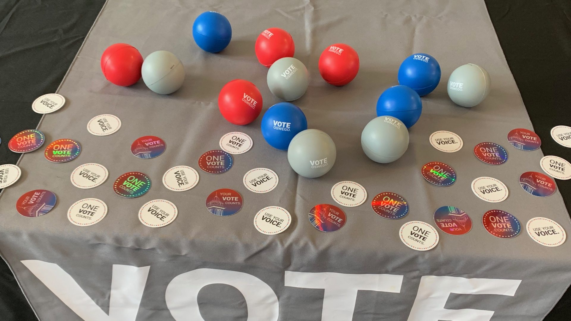 Vote Oswego - Image of table at event with stickers and stress balls