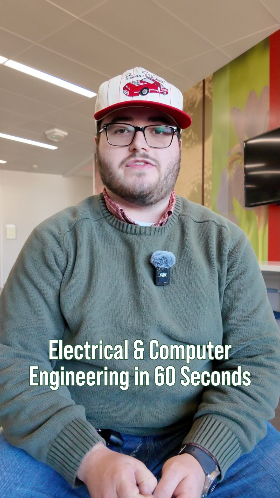 A student sits inside the Shineman Center with a microphone clipped to his sweater, with on-screen text reading “Electrical & Computer Engineering in 60 Seconds.”