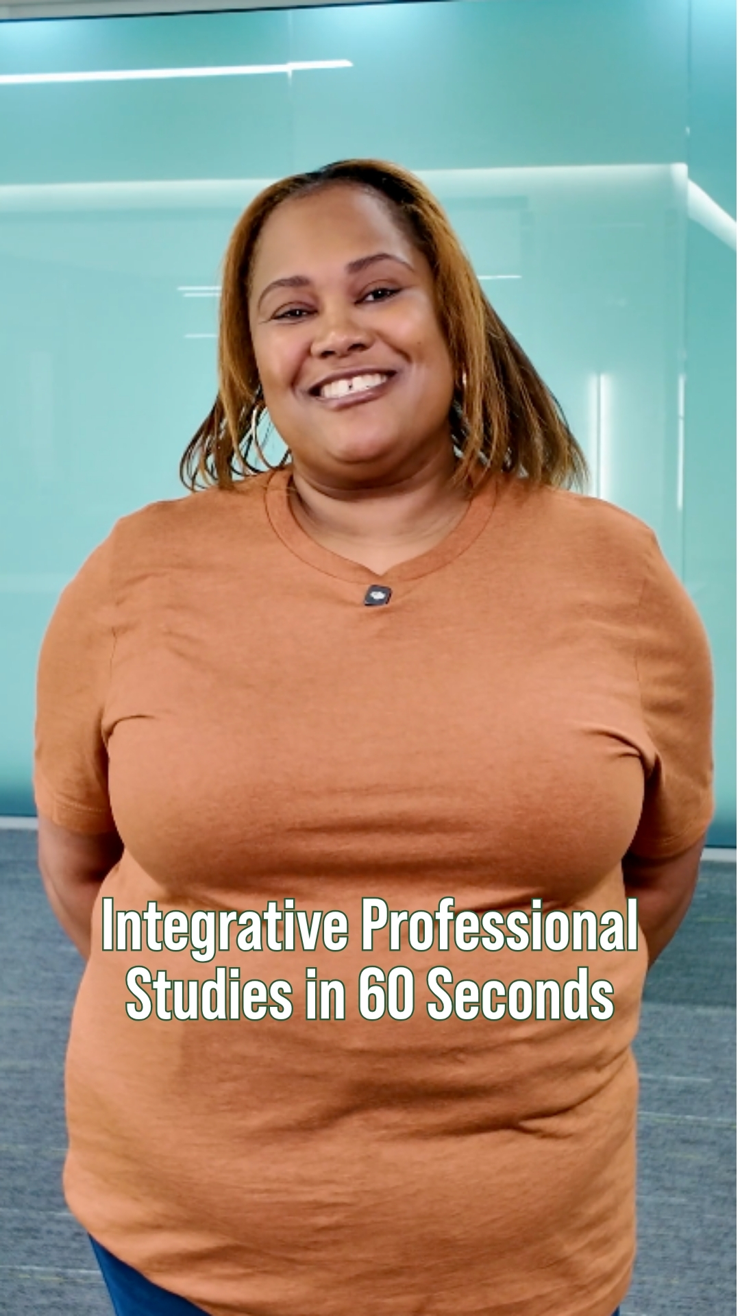 A smiling student stands indoors in front of a teal wall with the text “Integrative Professional Studies in 60 Seconds” overlaid on the image.