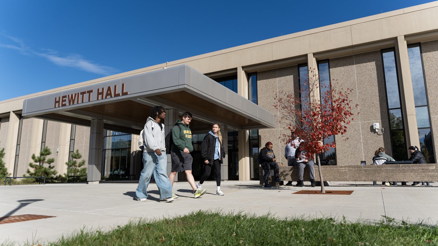 Students walking on the sidewalk outside the newly renovated Hewitt Hall