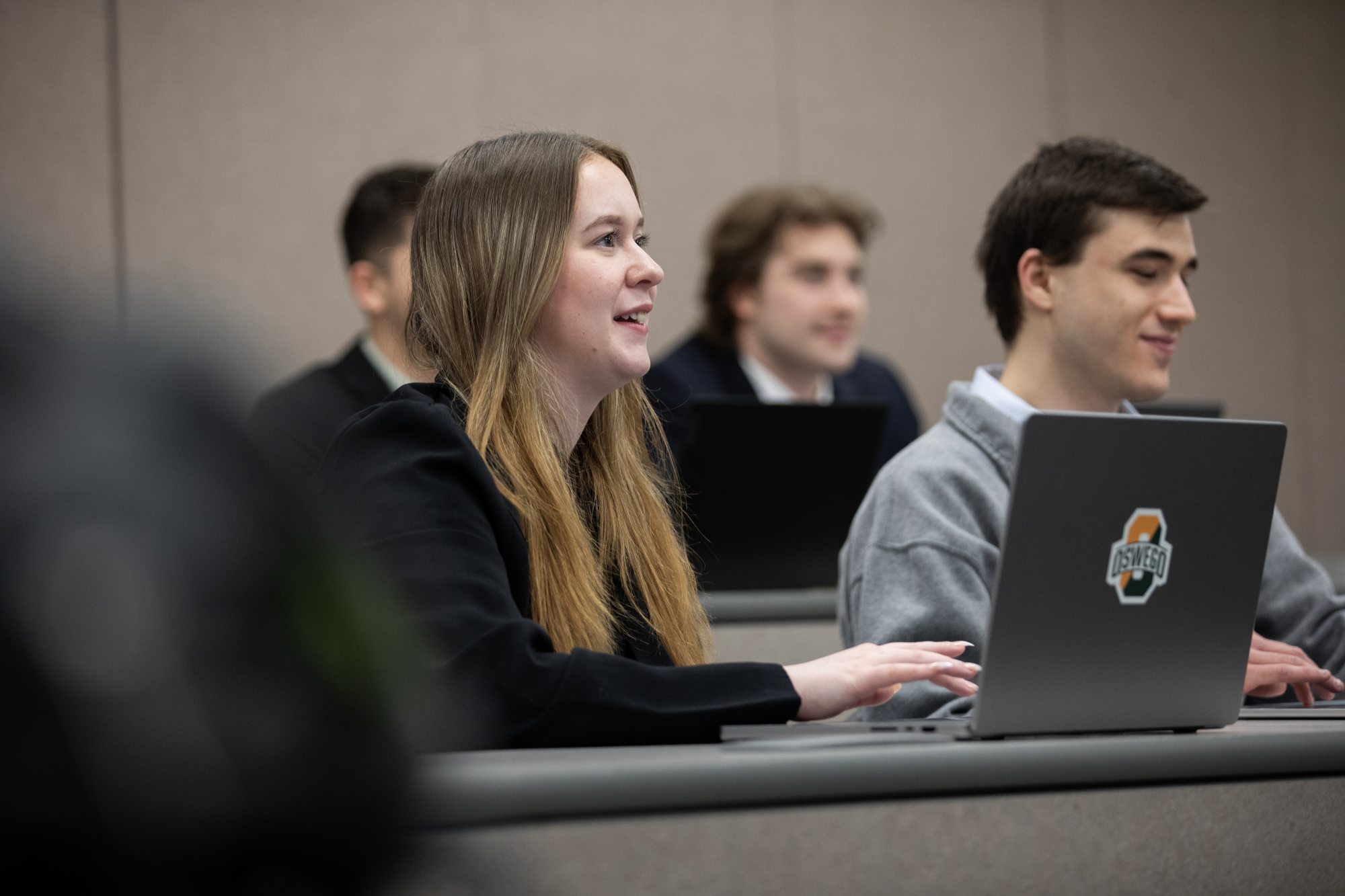 Public accounting students participate in a classroom discussion while using laptops.