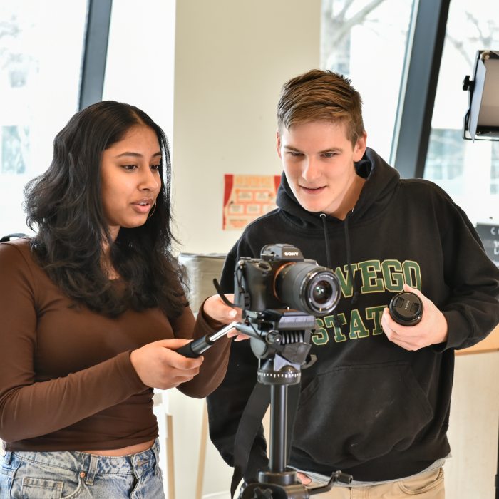 Cinema and screen studies students work with professional camera equipment and studio lighting.