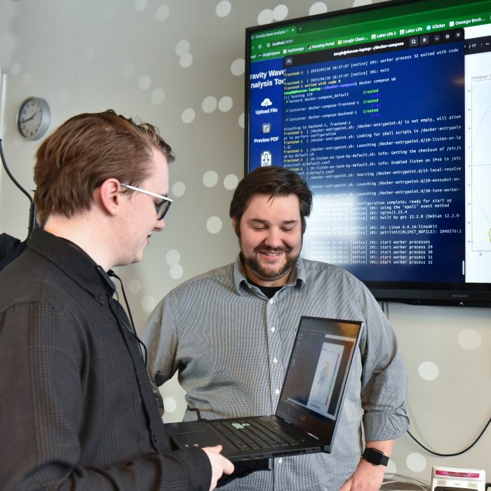 Professor and student looking at code on a computer.