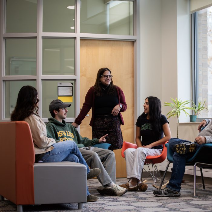 Instructor facilitating a discussion with students in a collaborative classroom setting.