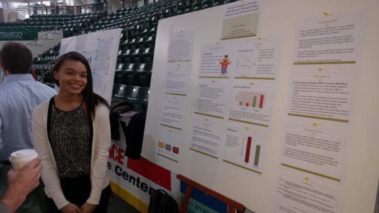 Student standing next to her presentation board 
