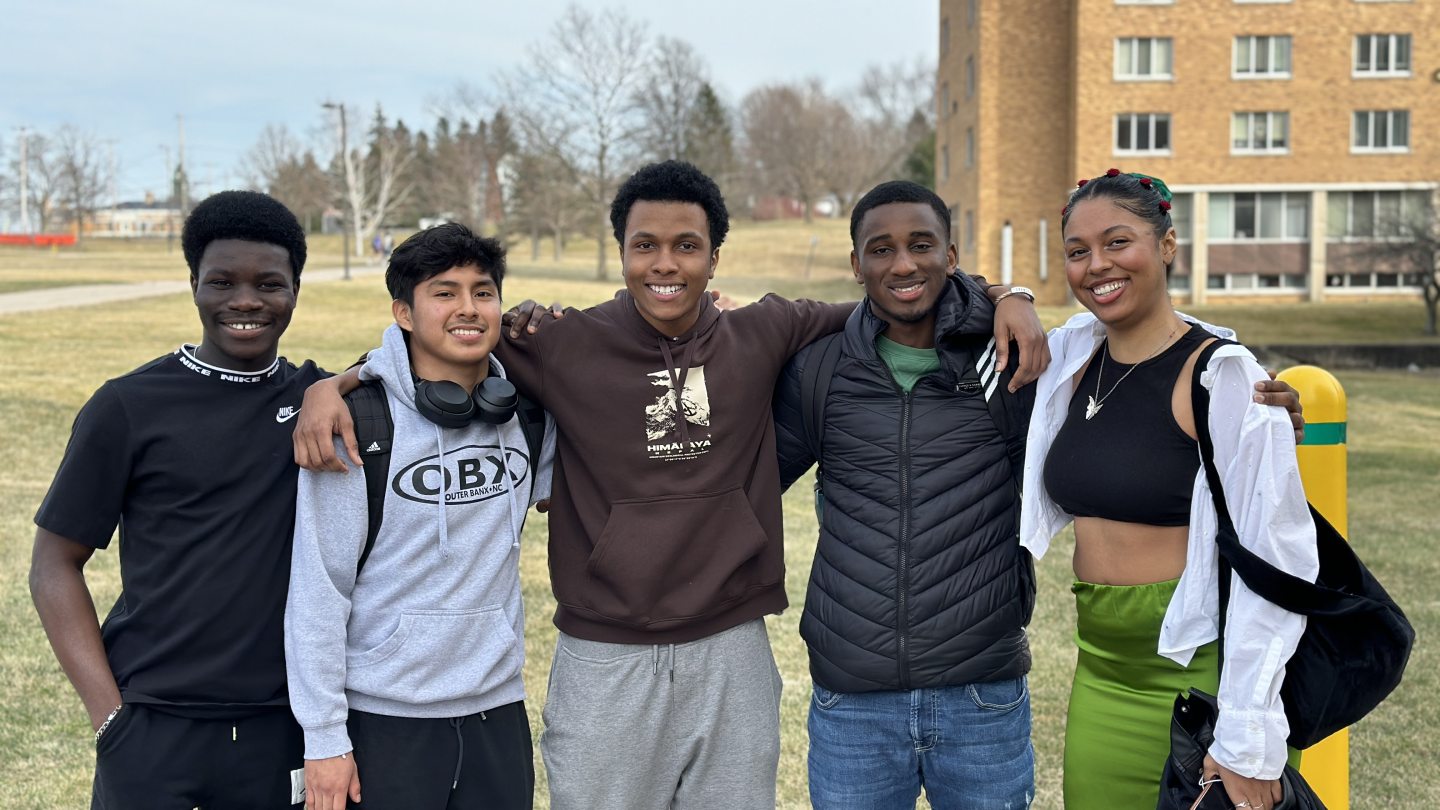 5 Students posing next to Hart Hall 