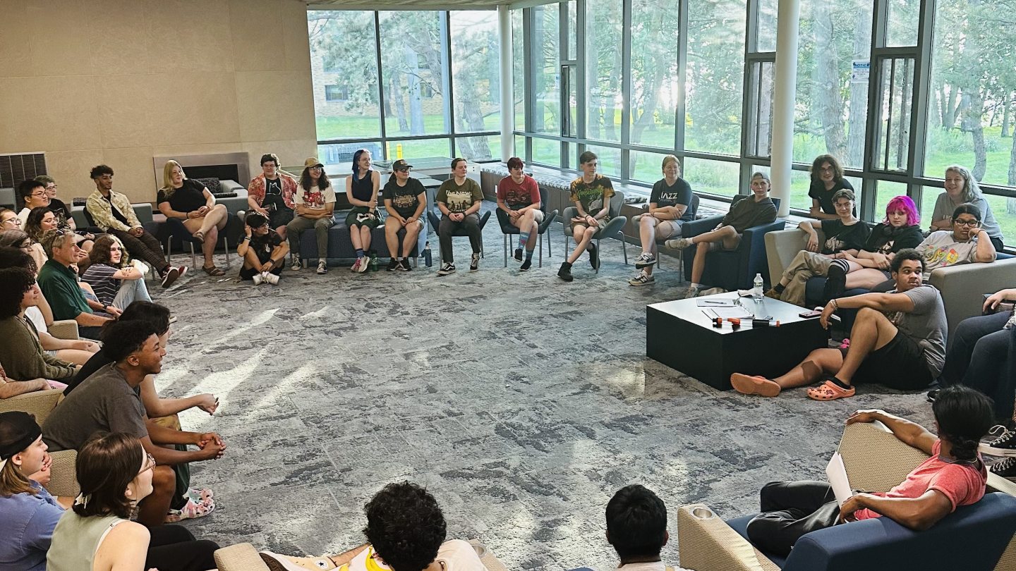 Group of students sitting in a circle in the main lounge Waterbury Hall.  