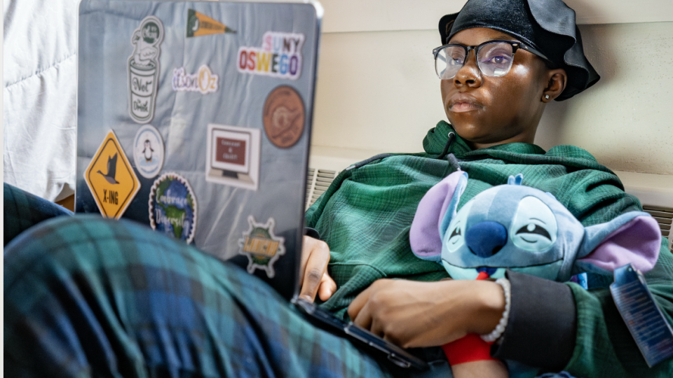 Student sitting on their lazy bag with a laptop. 