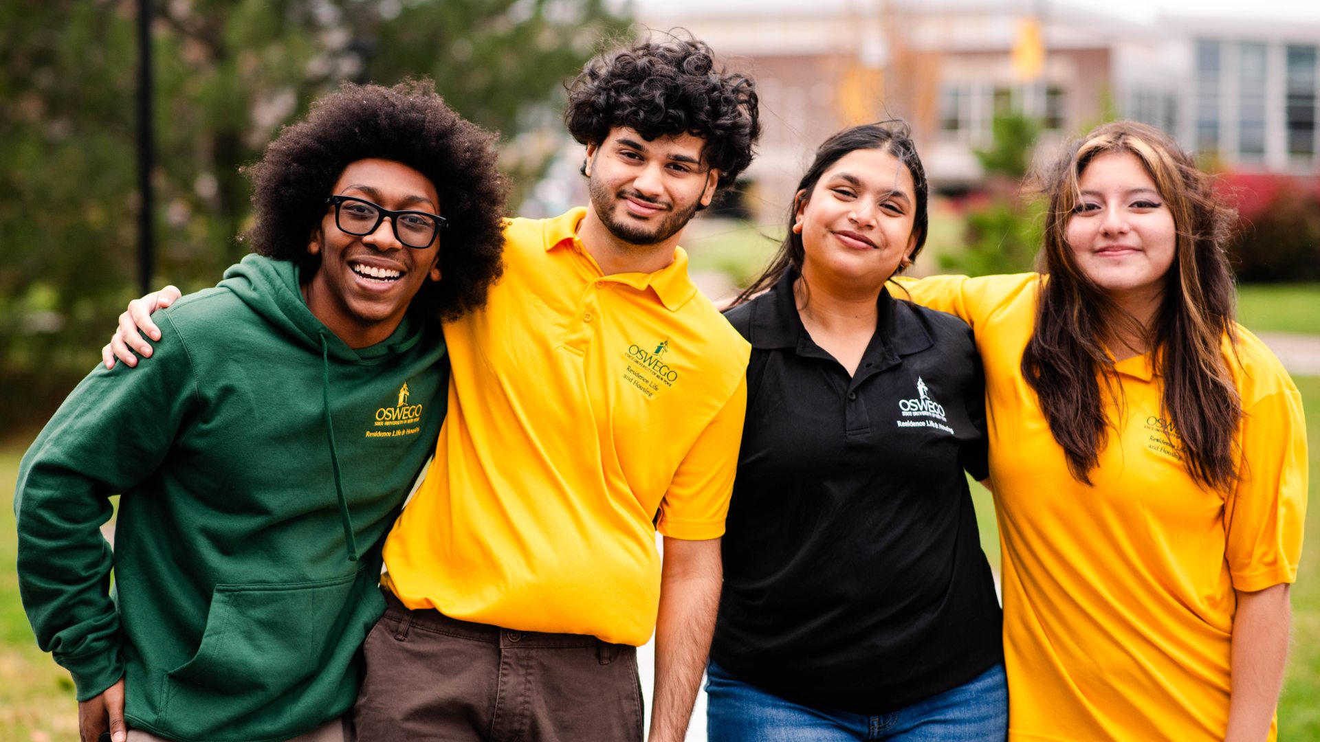 Four RA's wearing their RA polos on the lawn
