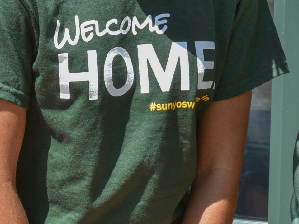 Close-up of a green "Welcome Home" shirt