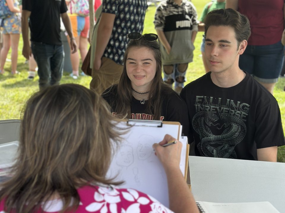 Students having their caricatures drawn. 