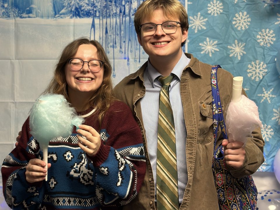 Two students holding cotton candy. 
